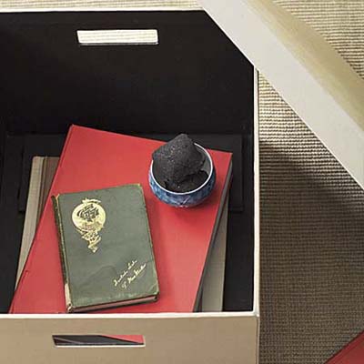 piece of charcoal in a jar in a box filled with old books
