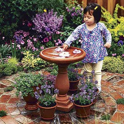 do-it-yourself, easy, affordable upgrade: little girl playing with bird bath in garden