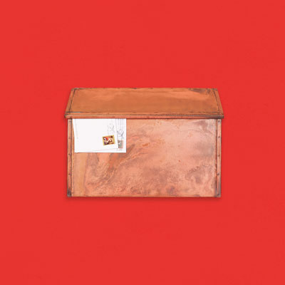 a brass wall-mount mailbox with an patinated finish made to look weathered with age