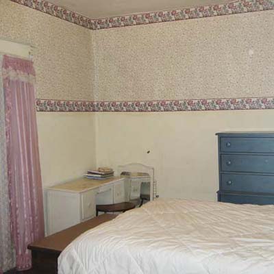 outdated bedroom with wallpaper and tiny closet