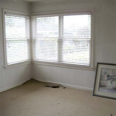 outdated bedroom with white walls and tan carpet