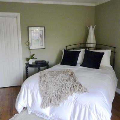 updated bedroom with white bed and sage green walls