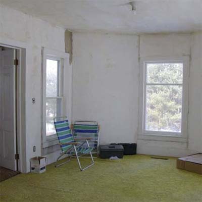 bedroom with green carpet and lawn chairs