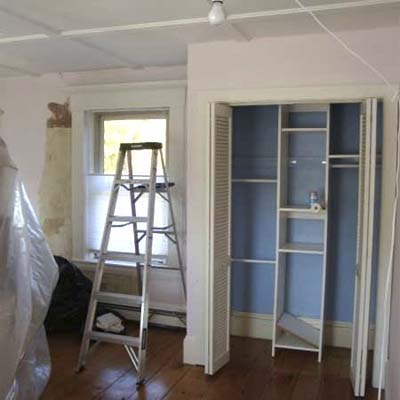 empty bedroom with open closet and ladder
