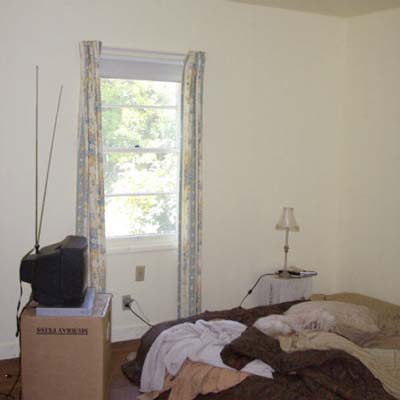 bedroom with bare walls and small television