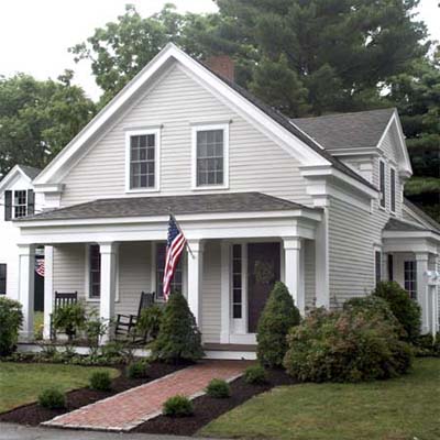 updated greek revival farmhouse with brick walkway