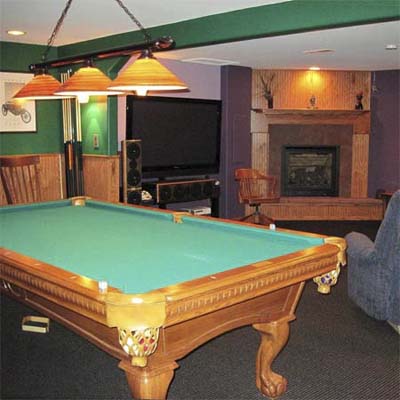 finished basement with pool table and fireplace