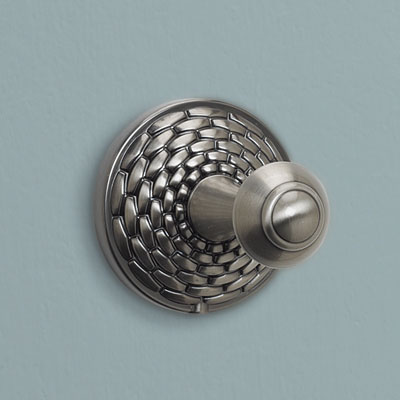 a brass robe hook with a basketweave design from Atlas Homewares with a brushed nickel finish