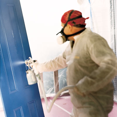 man spray painting door