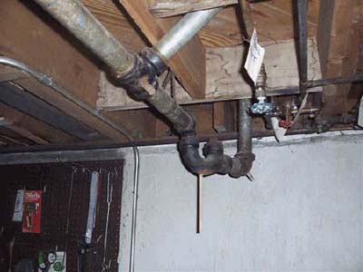 home inspection photo of wooden dowels plugging plumbing pipes