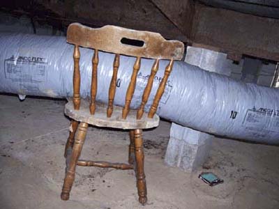 home inspection photo of chair supporting flex duct