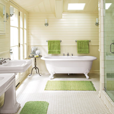 bathroom with clawfoot tub, hex tile, wainscoting, and green accents