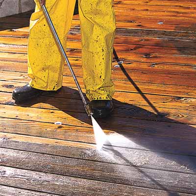 man powerwashing deck