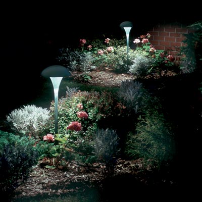 a flower bed illuminated by tulip-shaped outdoor lights