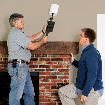 toh contractor tom silva discussing efficiency of a wall sconce with homeowner