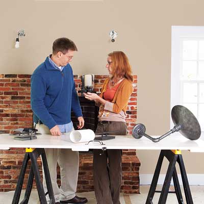 homeowner and lighting designer reviewing fixture options for efficient lighting