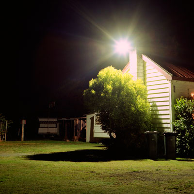 house with flood light illuminating yard