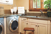 laundry room set up in garage with slated walls for storage