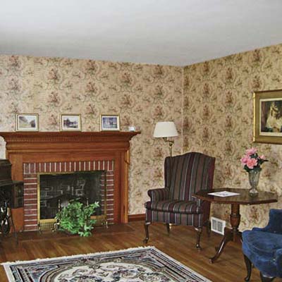 before photo of living room with wallpaper and old oak flooring in Cape Cod remodel