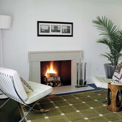 after photo of living room with white walls, new fireplace and floors in Cape Cod remodel