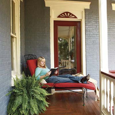 homeowner relaxing and reading a book on porch