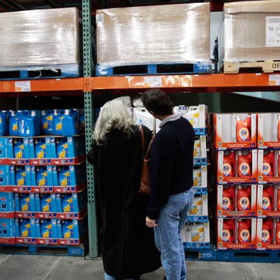 two shoppers looking at shelves of bulk items at a warehouse