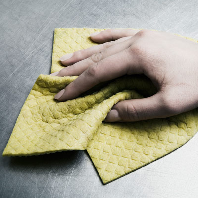 person cleaning a stainless steel surface