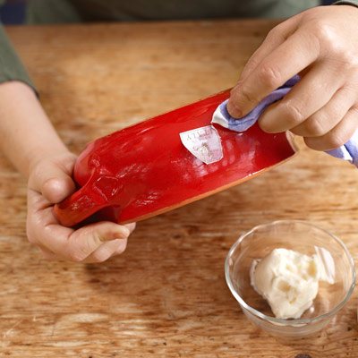woman rubbing off sticker residue with a cloth and mayonnaise