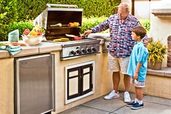 an outdoor kitchen with gas grill