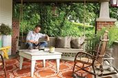a porch with porch swing and outdoor furniture
