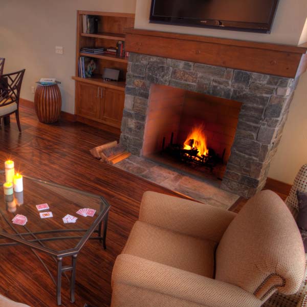 living room with fireplace, fire roaring and hardwood floors