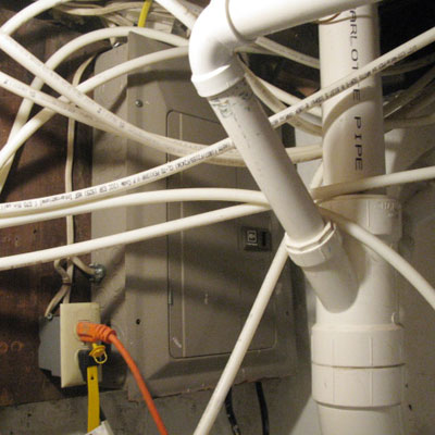 a twisted mess of cables in front of a breaker box