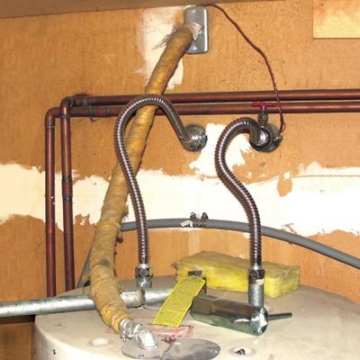 an insulated electrical cable hovering over uninsulated heating pipes