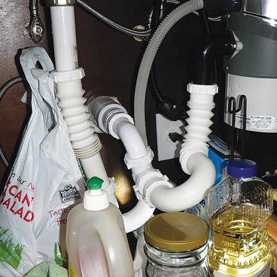 a convoluted trap arrangement under a kitchen sink