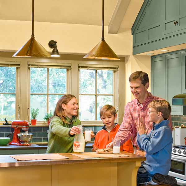 family gathered after whole-house renovation in kitchen with vaulted cathedral ceiling