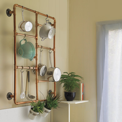 kitchen pot rack made of copper pipes hanging on wall 