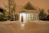 House at dusk after heavy snow storm with shoveled path