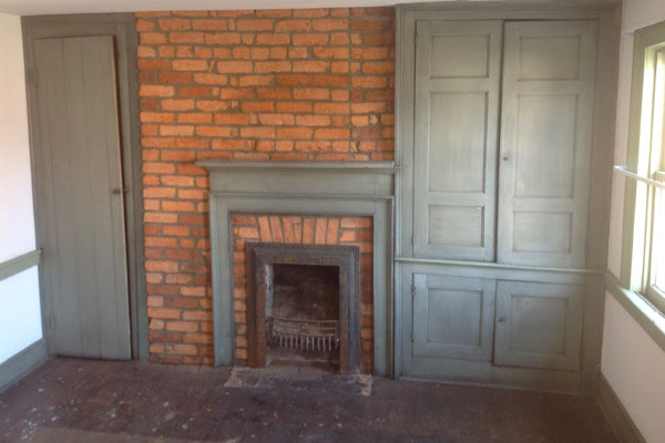 Save This Old House West Newton, Pennsylvania interior mantel with exposed brick wall and built-in storage