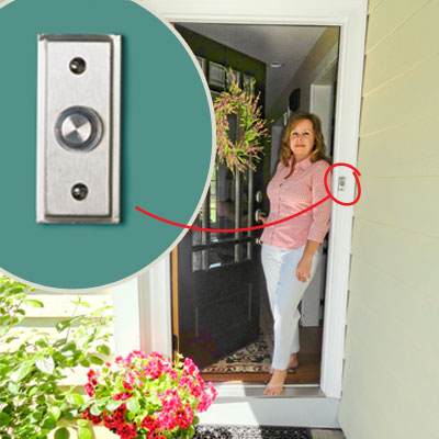homeowner demonstrating how an new satin-finish doorbell compliments her handle and lockset