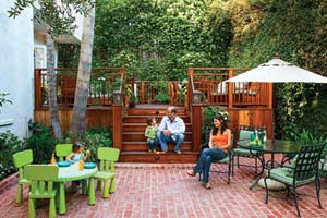 family on rebuilt backyard deck with brick patio