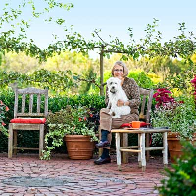 homeowner with dog on circular patio with pear and apple trees in autumn garden 
