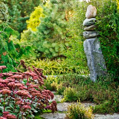 stone cairn beside pathway with Sedum 'Matrona', teucrium