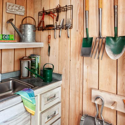 potting shed interior with redwood floor, pine plank walls, peg racks 