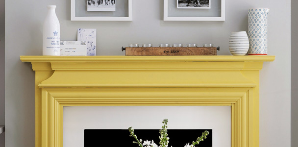 yellow painted mantel in gray and white living area