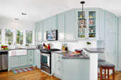 open kitchen after remodel with painted blue cabinets, angled quartz countertop