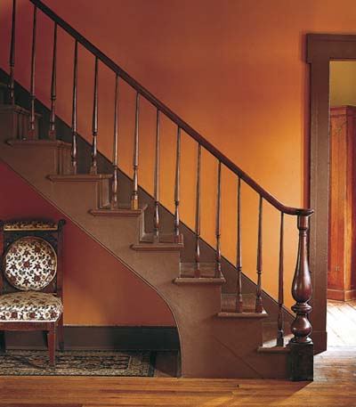orange walls and walnut staircase
