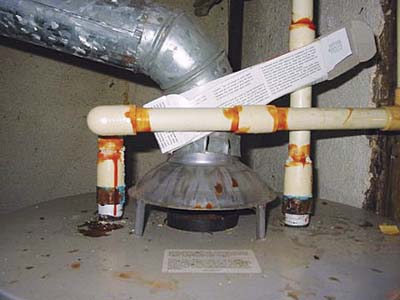 home inspection photo of cardboard between plastic pipe and flue pipe