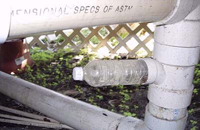 home inspection photo of plastic water bottle capping sewage pipe