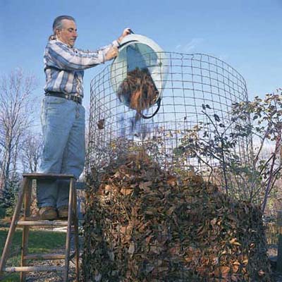 man throwing leaf debris onto his compost pile