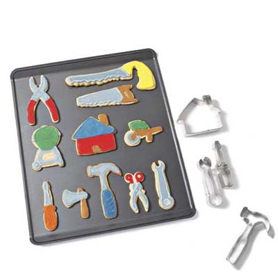 a cookie baking sheet with tool shaped cookies and cookie cutters to the side
